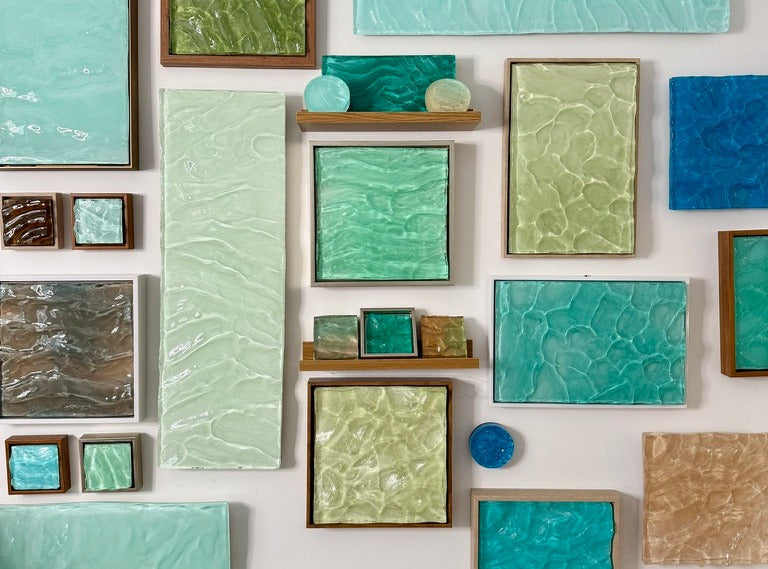 A wall of Ashley Mossy's framed and unframed resin pieces